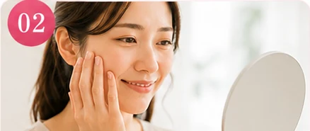 頬に手を添えてハリを確かめる女性